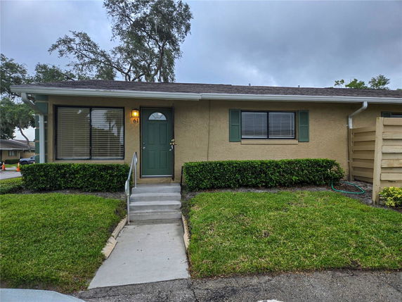 Front view of a single-story house with green door and windows.