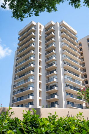 Front view of a multi-story apartment building with balconies.