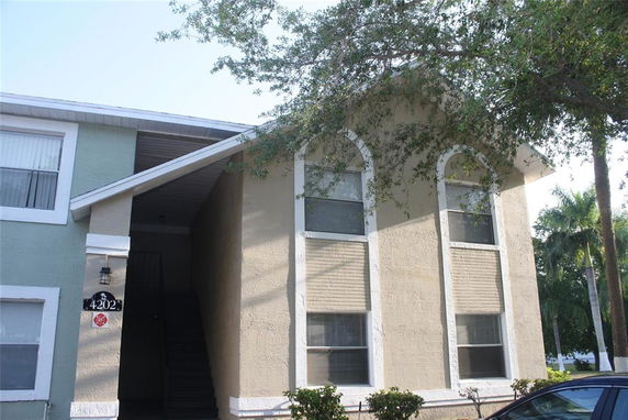 Front view of a building with arched windows and a staircase entrance.