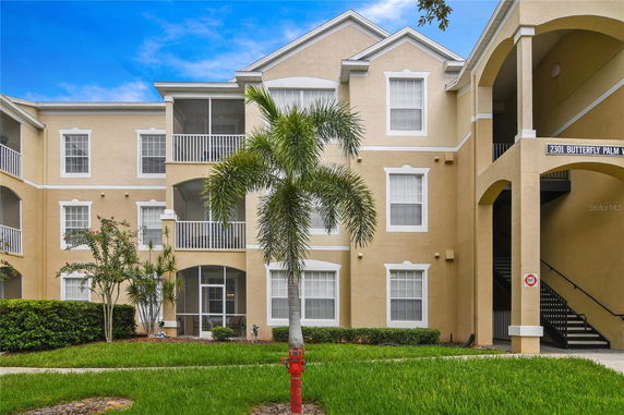 Front view of a multi-story building with balconies and arched entrance.