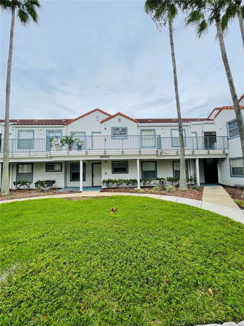 Front view of a two-story building with balconies and a courtyard.