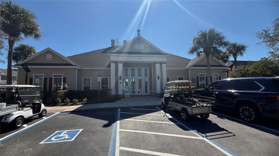 Front view of a building with a porch entrance and parking area.