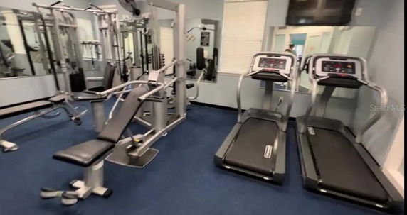 Indoor gym area with exercise equipment including treadmills and weight machines.