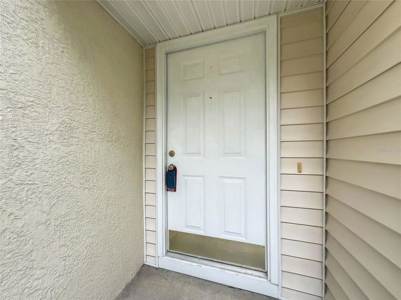 Close-up view of a front door with beige siding.