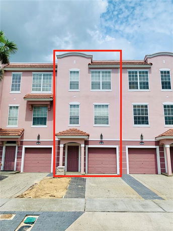 Front view of a multi-story townhouse with a single garage and symmetrical windows.
