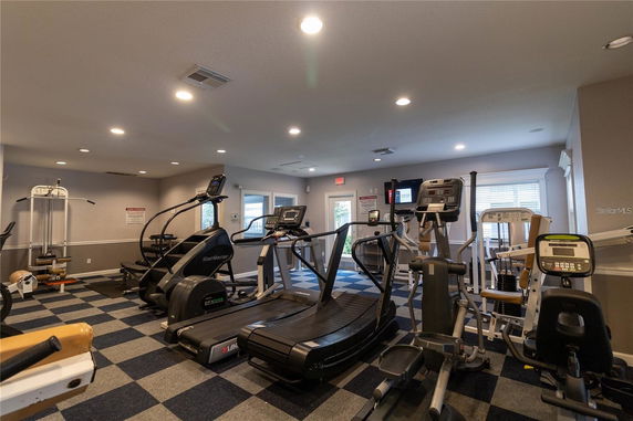 Indoor gym area with exercise equipment and machines.