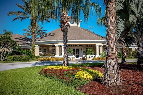 Front view of a large single-story building with a circular entrance and landscaped garden.