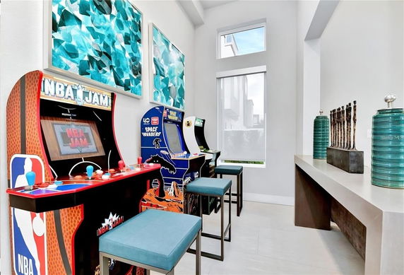 Interior room with arcade game machines and stylish decor.