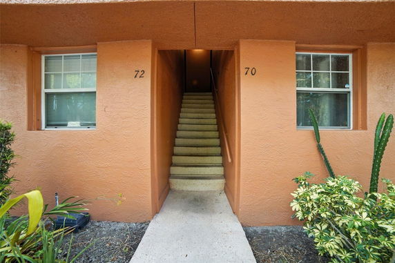 Front view of a building entrance with stairs leading up.