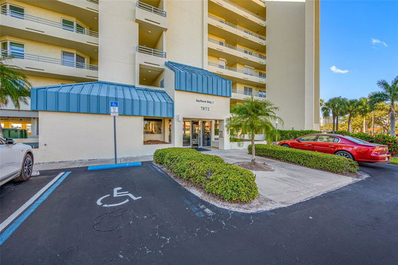 Front view of a multi-story building with balconies and an entrance canopy.