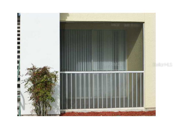 Front view of a house with a glass and metal railing balcony.