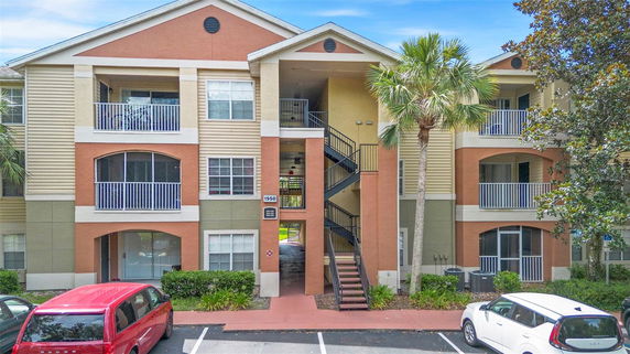 Front view of a multi-story apartment building with open balconies and a central staircase.