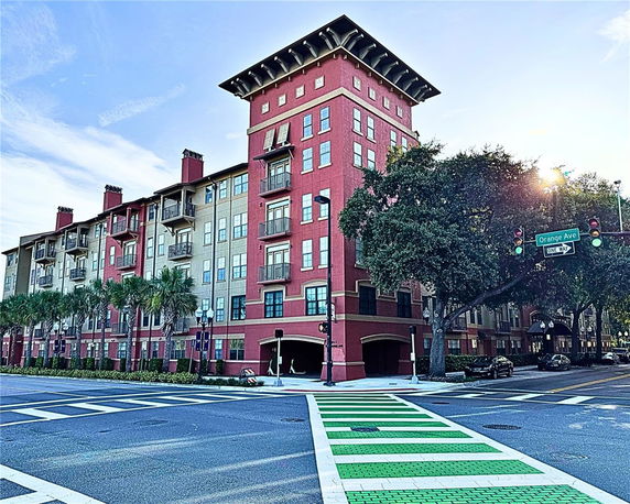 Front view of a multi-story apartment building at a street corner.