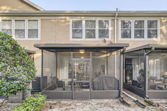 Rear view of a two-story house with a screened patio area.