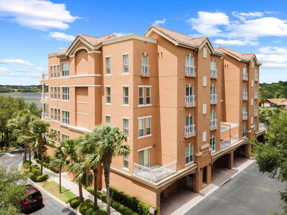 Front view of a multi-story building with balconies and a tiled roof.
