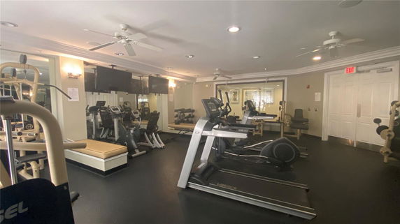 Indoor gym area with exercise equipment such as treadmills and weights.