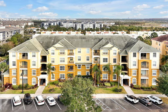 Front view of a multi-story residential building with a yellow and white facade.