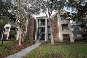 Front view of a multi-story apartment building with brick accents and external staircases.
