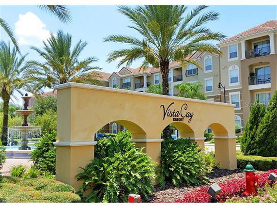 Front view of a resort building with arch structure and palm trees.