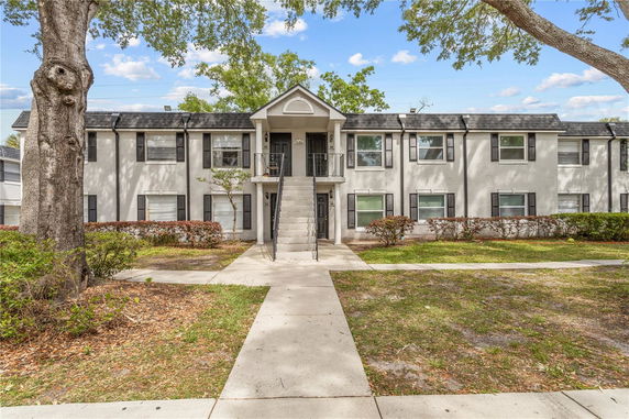 Front view of a two-story residential building with a central staircase and multiple windows.