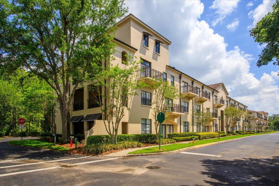 Front view of a multi-story residential building with balconies and a sloped roof.