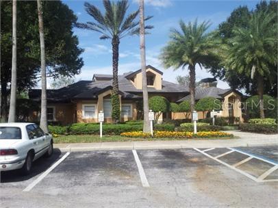 Front view of a single-story house with palm trees and parking area.