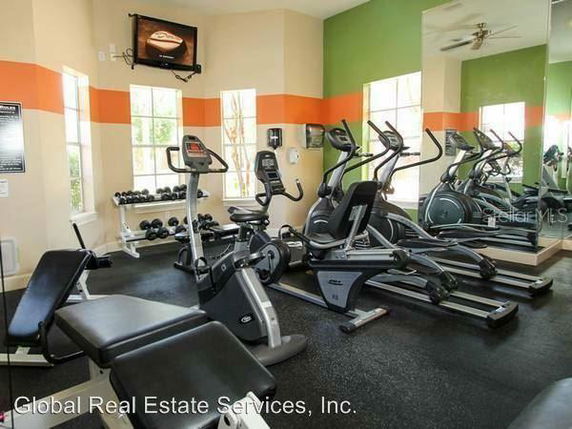 Indoor gym area with exercise equipment including treadmills, stationary bikes, and weights.