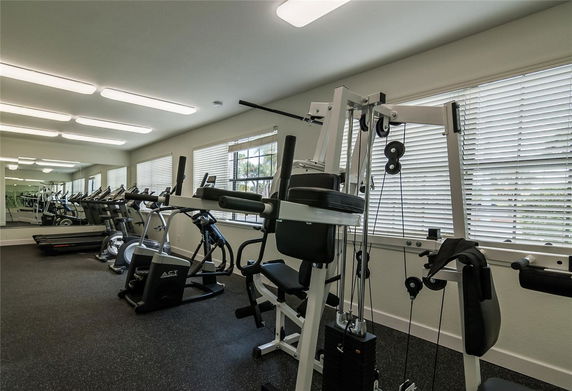 Interior view of a fitness room with exercise equipment and machines.