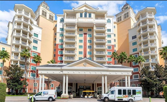 Front view of a multi-story building with balconies and a covered entrance.