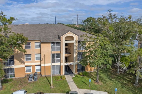 Front view of a three-story apartment building with balconies and a central entrance.