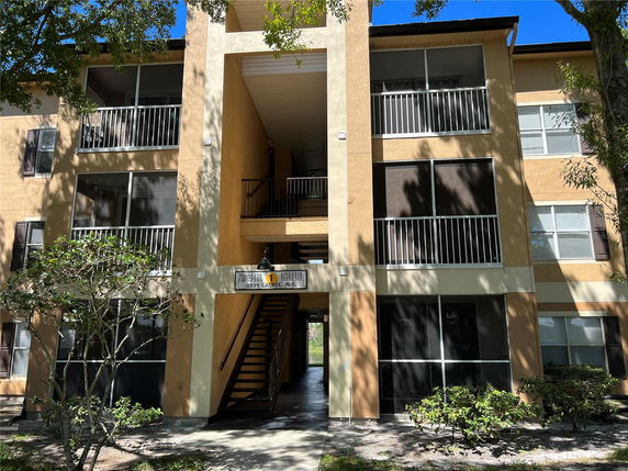 Front view of a multi-story apartment building with balconies.