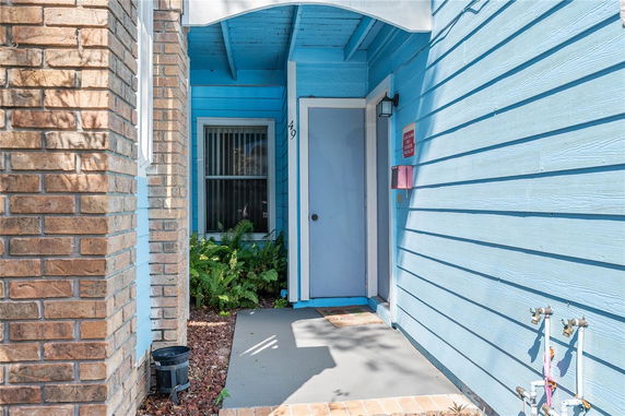 Entrance view of a house with blue siding and a covered porch.
