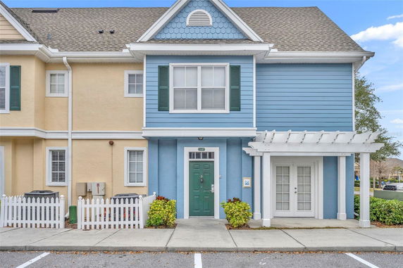 Front view of a townhouse with a blue facade and green door.