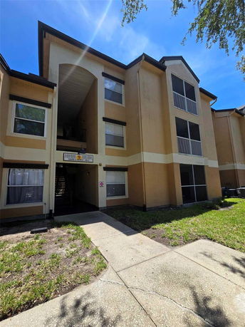 Front view of a multi-story residential building with an archway entrance.