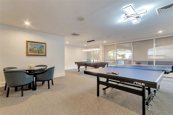 Indoor recreational room with table tennis and billiards tables.