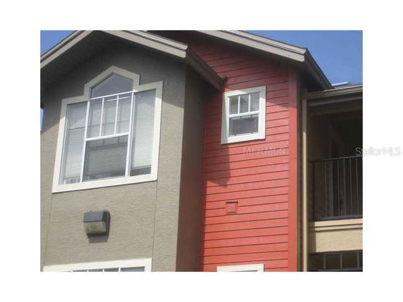 Partial view of a multi-story building with mixed siding and gabled roof.