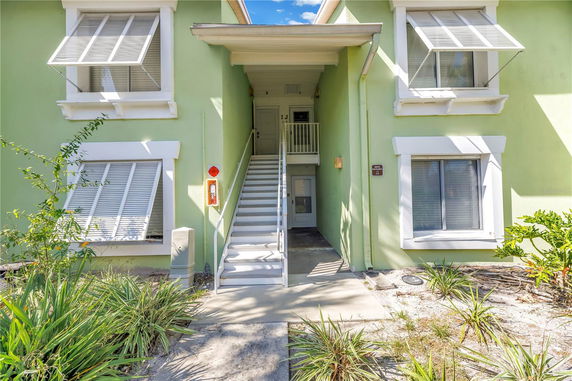 Front view of a building with green walls and white window frames.