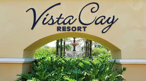 Entrance sign of Vista Cay Resort with surrounding greenery.