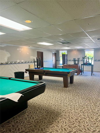 Room with billiard tables and chairs stacked on top.