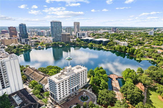 Panoramic view of a cityscape with high-rise buildings around a large lake.