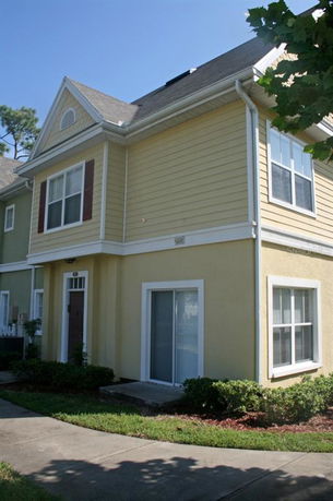Front view of a two-story house with yellow siding and white trim.