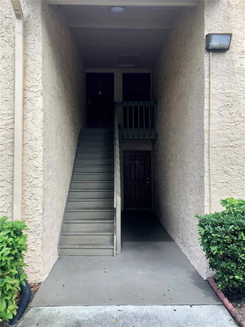 Front view of a building entryway with stairs leading to the upper floor.