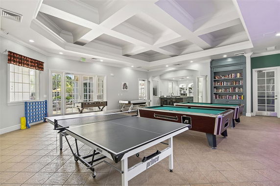 Indoor recreation room with table tennis, pool tables, and a bookshelf.