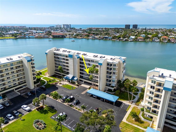 Panoramic view of a residential complex by the water with multiple multi-story buildings.