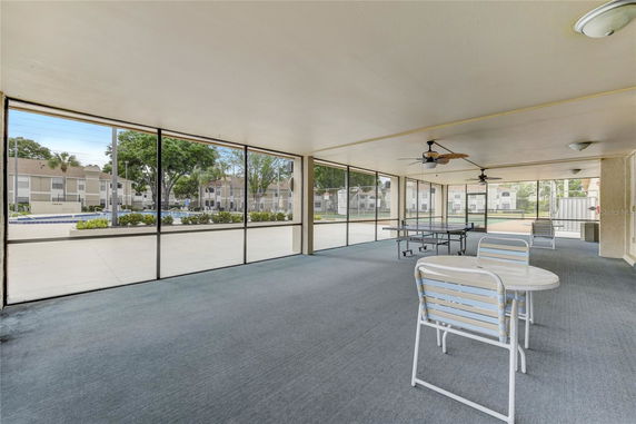 Indoor recreational area with table tennis and outdoor view.