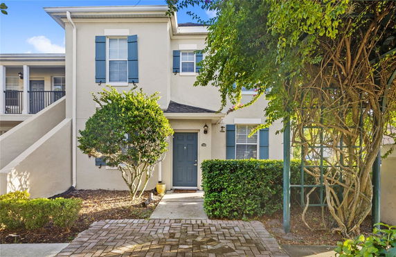 Front view of a two-story residential building with blue shutters and a main entrance door.