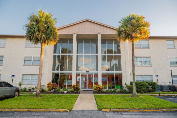 Front view of a multi-story building with large glass entrance.