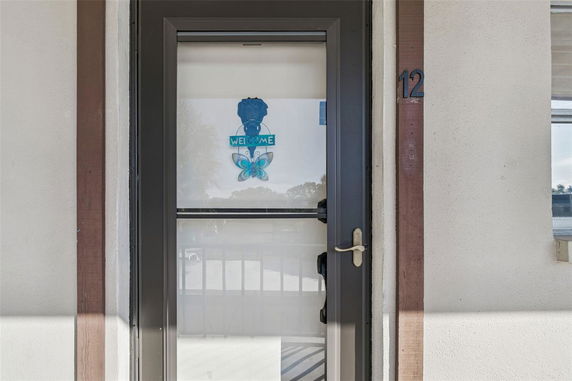 Entrance door with a welcome sign and glass panel on a building.