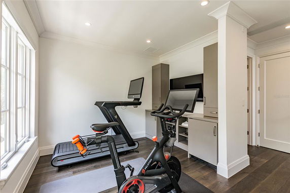 Room with exercise equipment including a treadmill and stationary bike.