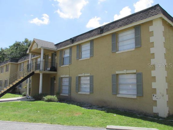 Front view of a two-story apartment building with a staircase leading to the second floor.